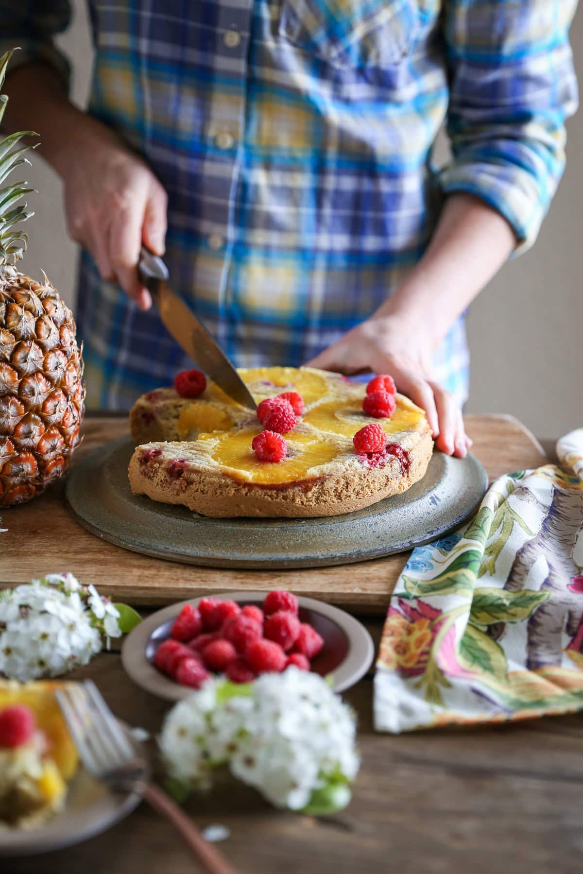 Woman cutting an upside down cake on a cutting board