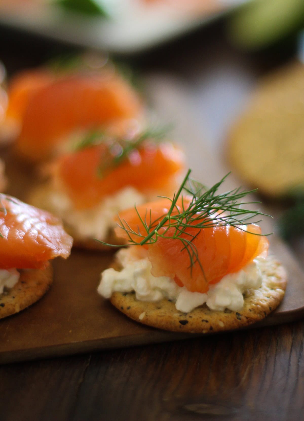 Cured salmon on a cracker with cottage cheese and fresh dill, ready to eat.