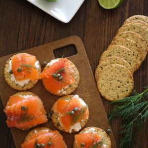 Cured salmon on crackers with fresh dill and capers, ready to serve.