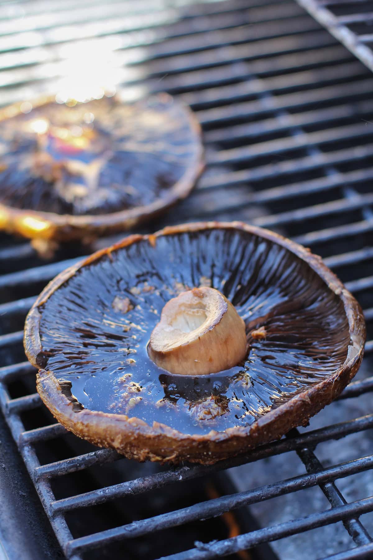 Portobello mushroom cap side down on a grill, grilling to perfection.