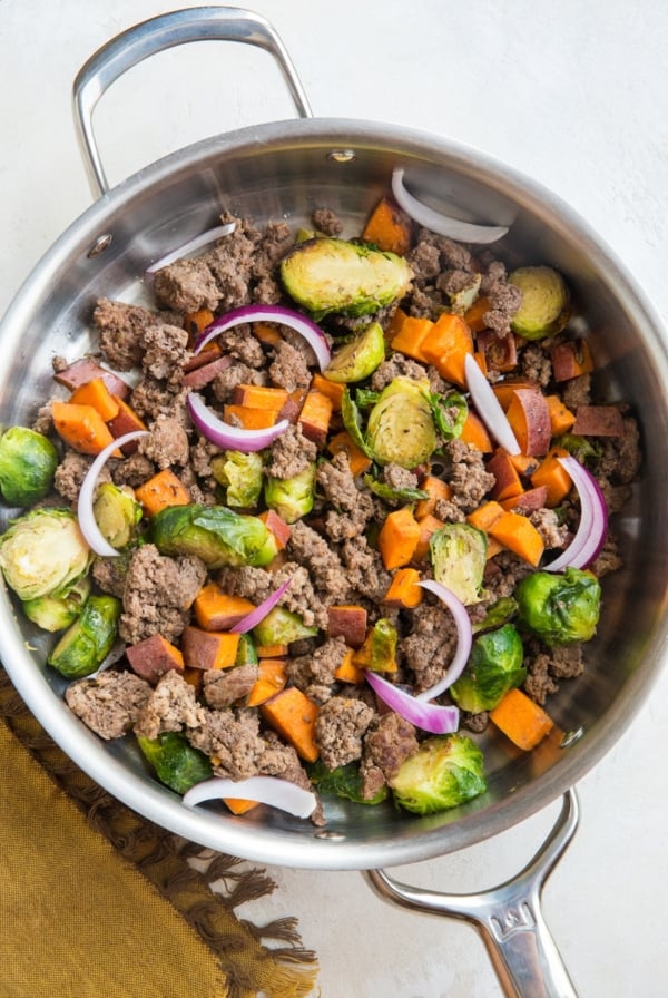 Ground Beef and Sweet Potato Skillet with Brussel Sprouts in a stainless steel skillet. A napkin to the side, ready to serve.