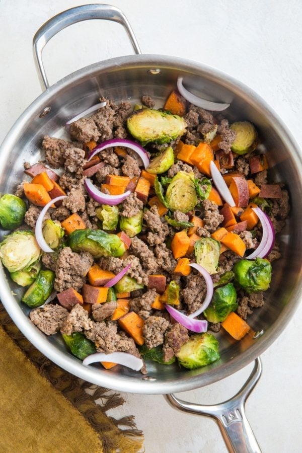 Ground Beef and Sweet Potato Skillet with Brussel Sprouts in a stainless steel skillet. A napkin to the side, ready to serve.