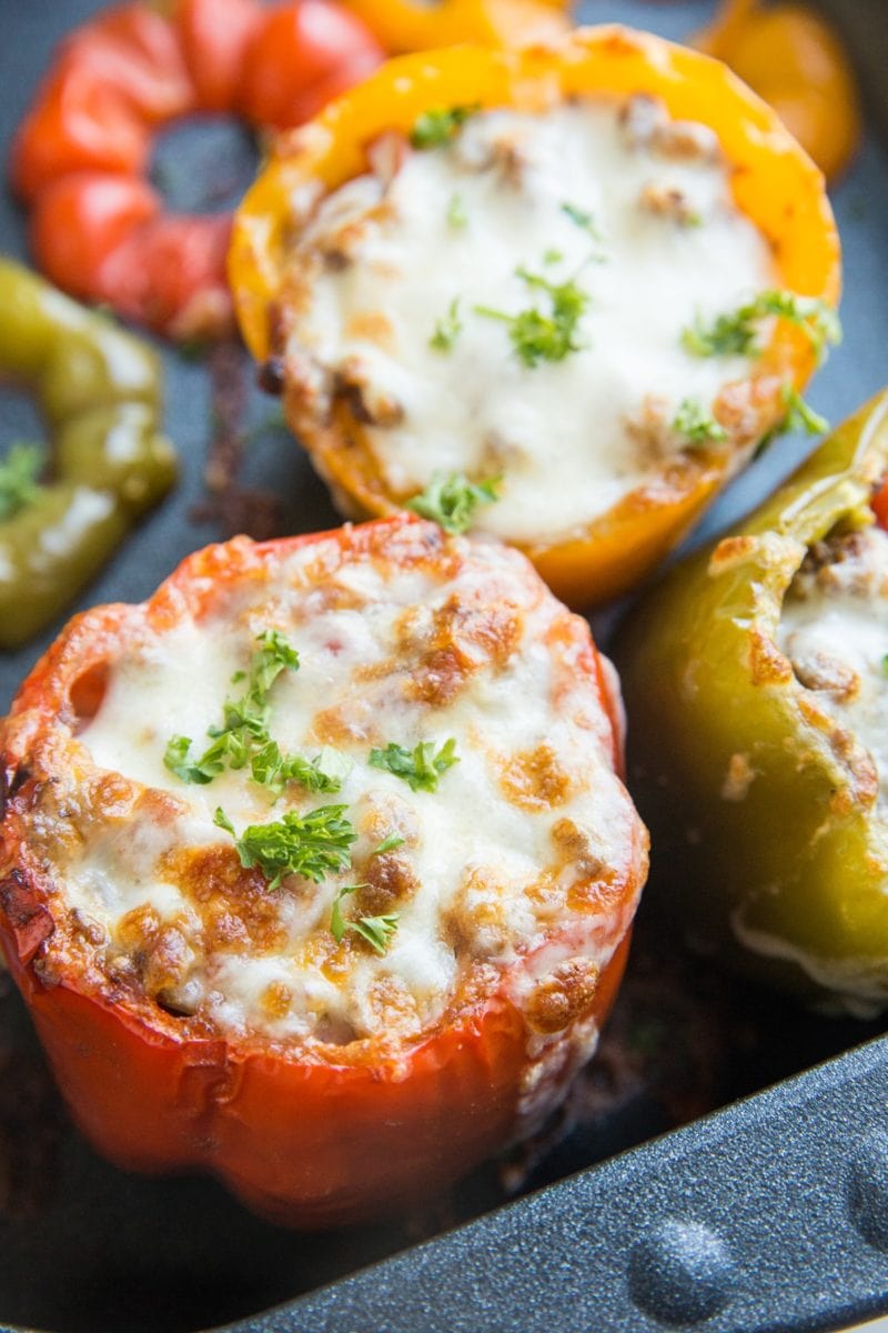 Large casserole dish filled with taco stuffed peppers with cheese on top, fresh out of the oven and ready to serve.