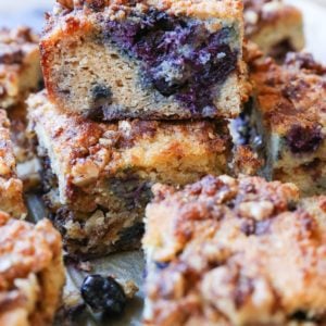 hunks of paleo blueberry coffee cake stacked on top of each other, revealing the fresh berry inside.