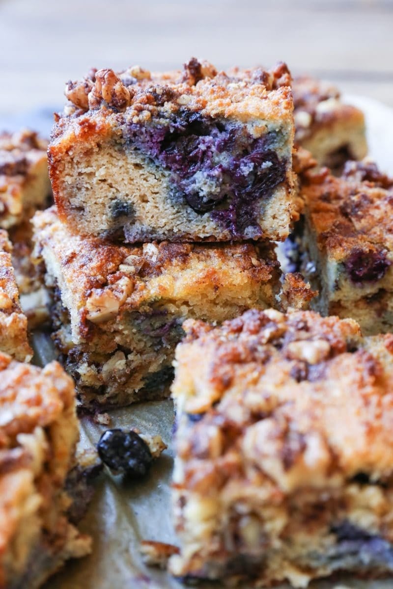 hunks of paleo blueberry coffee cake stacked on top of each other, revealing the fresh berry inside.