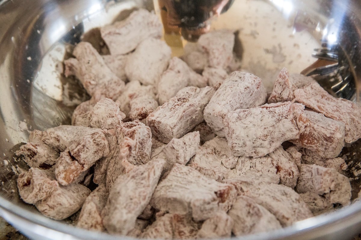 Beef and tapioca flour in a mixing bowl to make mongolian beef.