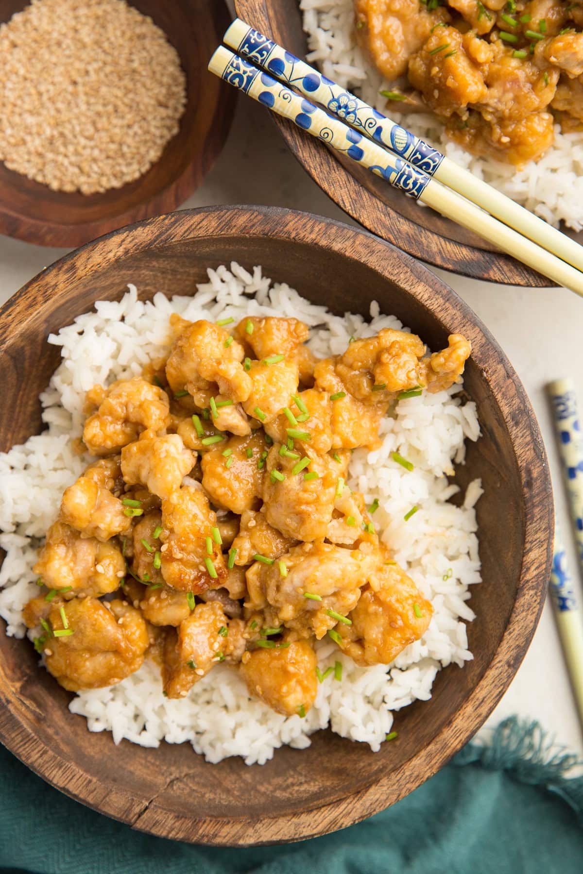 Wooden bowl full of rice and orange chicken