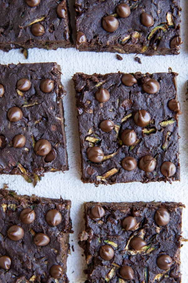 Top down photo of cut zucchini brownies on a white background.