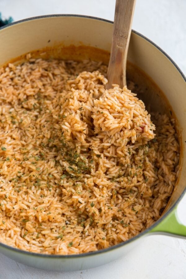 Big Dutch oven pot of Spanish rice with a wooden spoon, ready to serve.