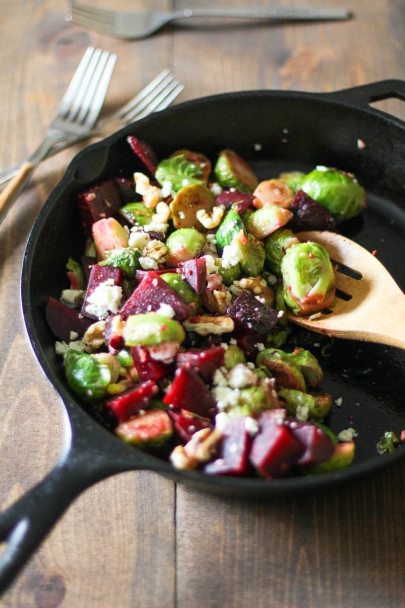 Cast iron skillet of sauteed brussel sprouts and beets, ready to serve.