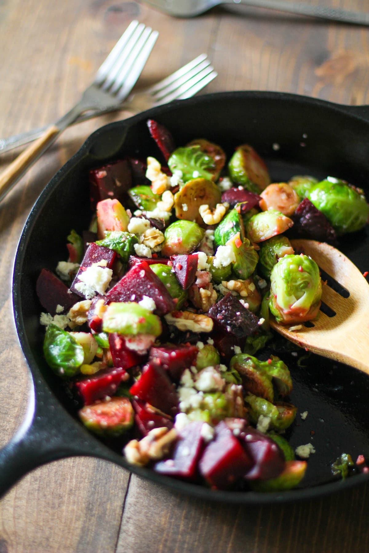 Cast iron skillet full of brussels sprouts and beets.