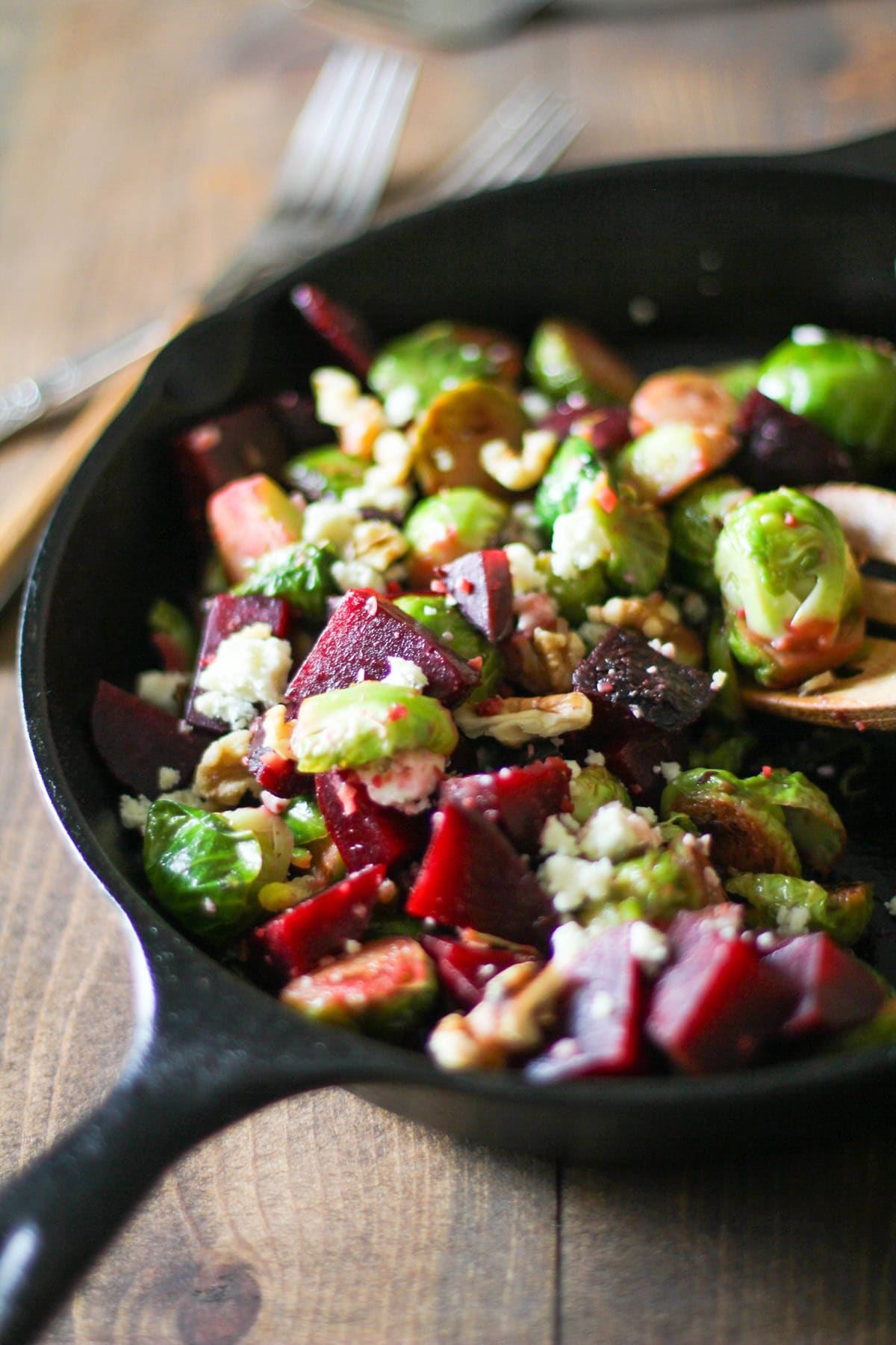 Cast iron skillet with sauteed Brussel sprouts and beets inside.