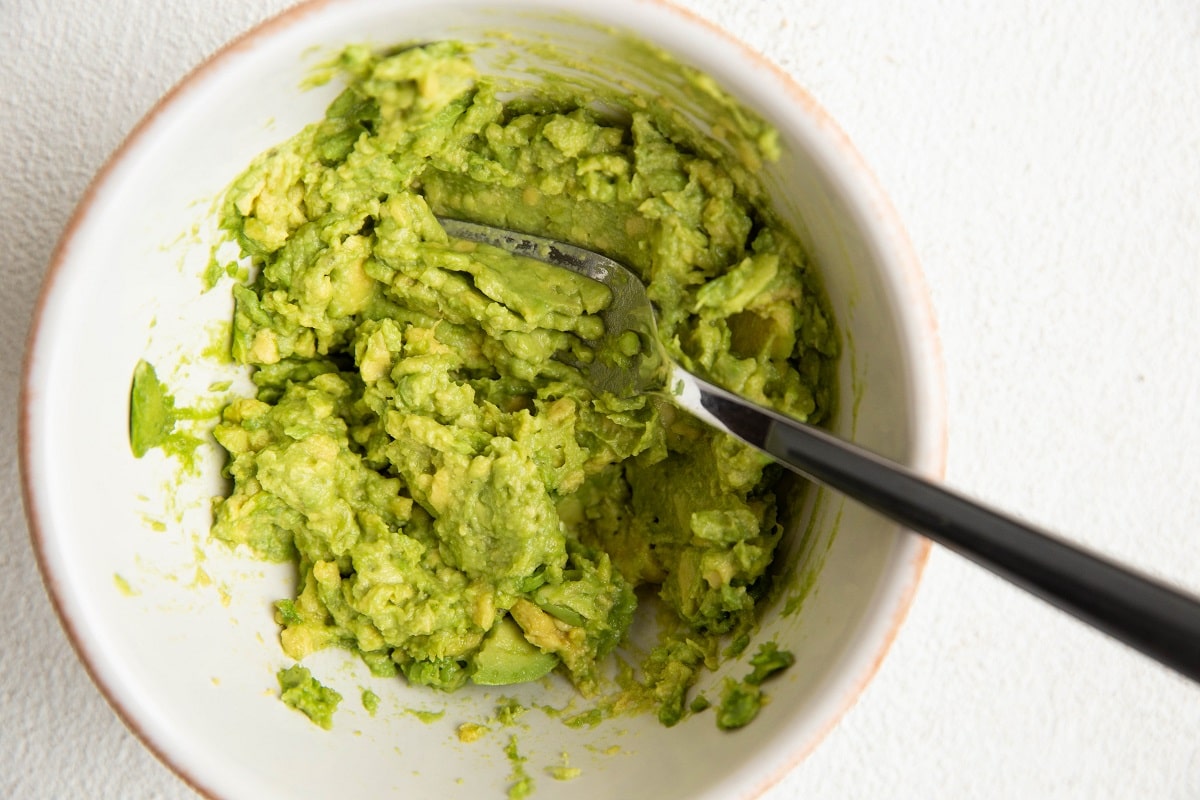 Mashed avocado in a small bowl.