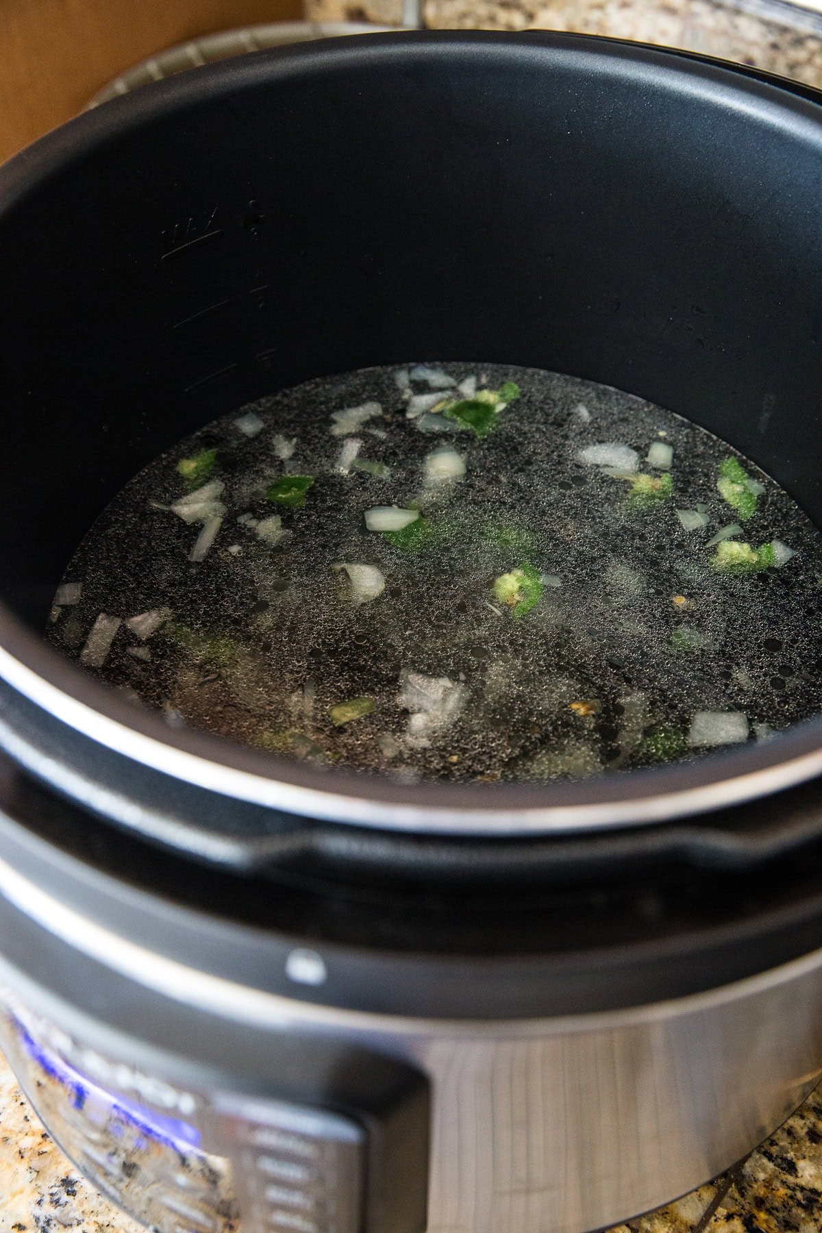 Pressure cooker full of ingredients for black beans.