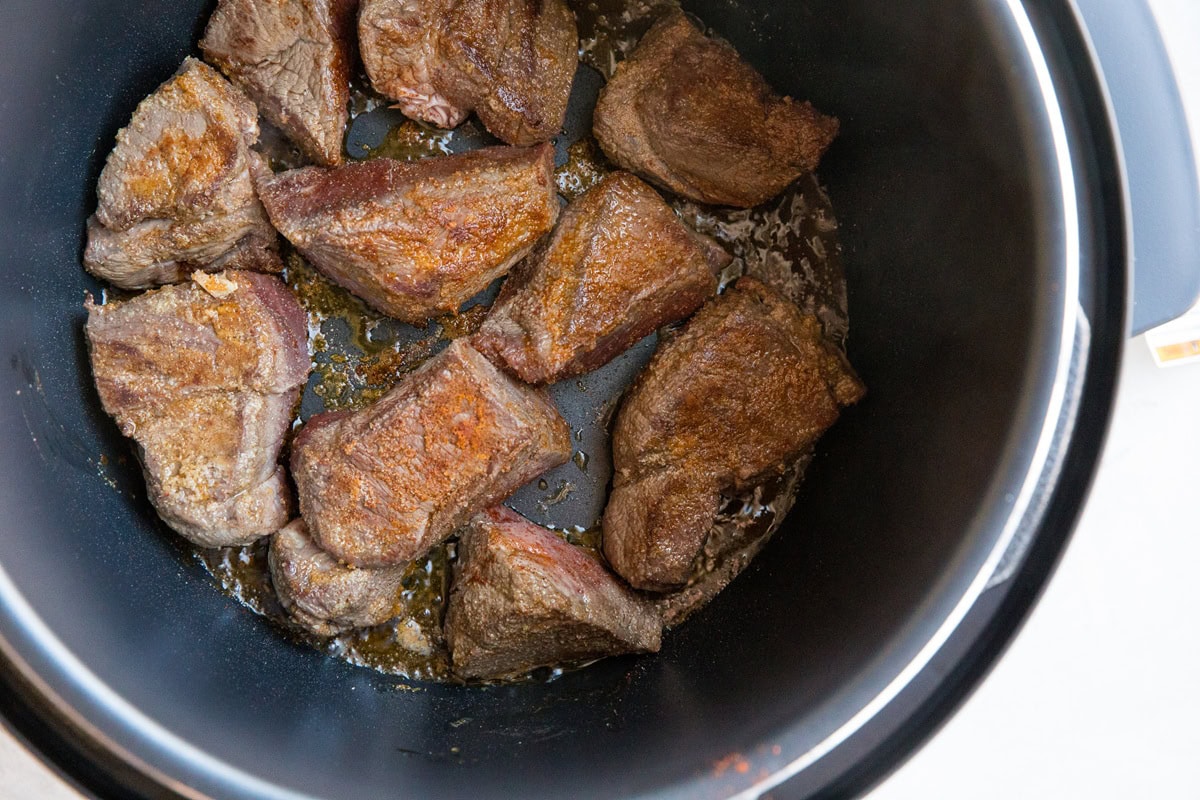 Seared chuck roast in an instant pot to make pot roast.