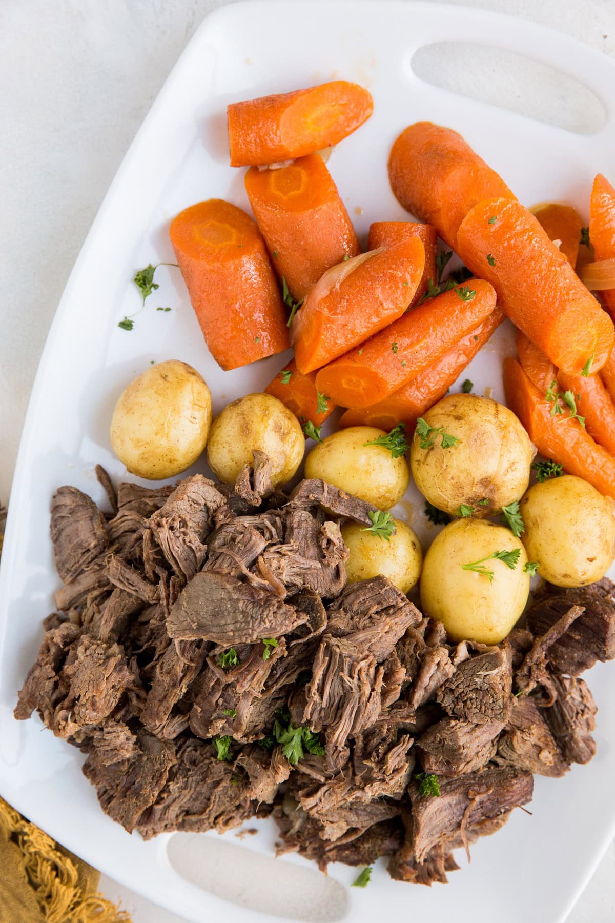 Instant Pot Pot Roast - an easy method for cooking pot roast that turns out deliciously. Platter of shredded beef with carrots and potatoes