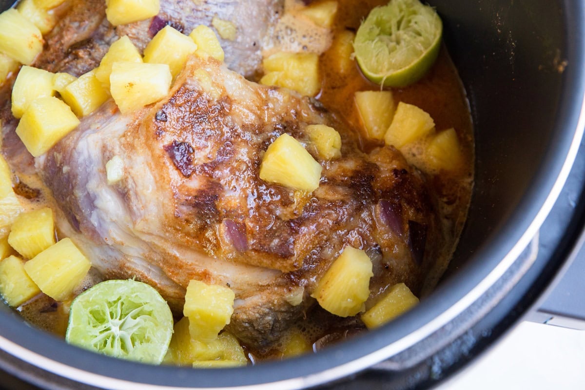 Pork roast in an instant pot with pineapple and limes.