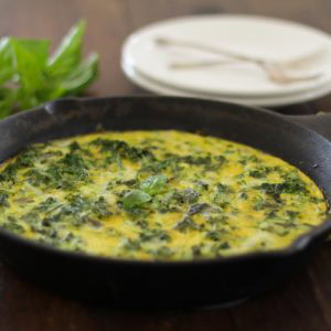 Cast iron skillet with a kale and zucchini frittata inside.