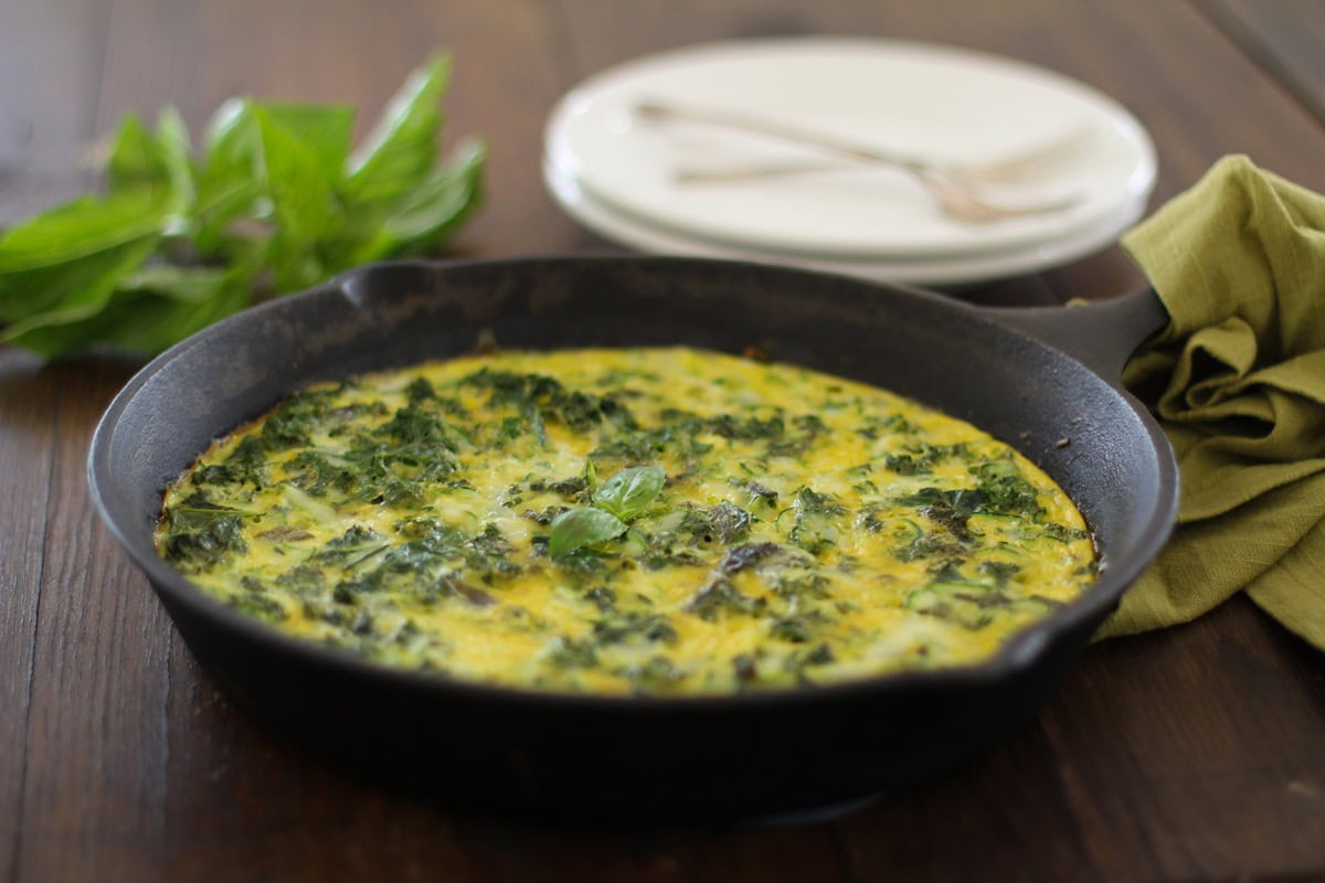 Cast iron skillet with a kale and zucchini frittata inside.