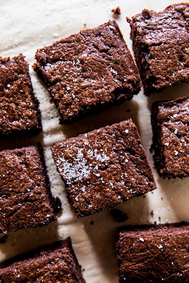 Keto brownies on a sheet of parchment paper, cut into individual slices.