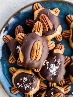 Blue plate full of pecan turtles. Sugar-free pecan turtle candy.