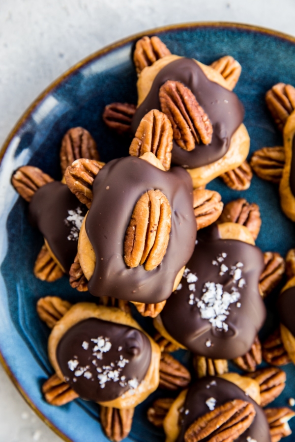 Blue plate full of pecan turtles. Sugar-free pecan turtle candy.
