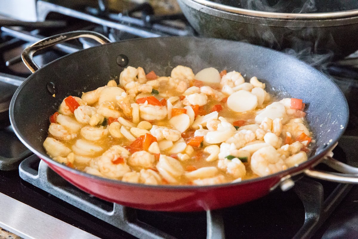 Kung pao shrimp cooking in a skillet to thicken the sauce.