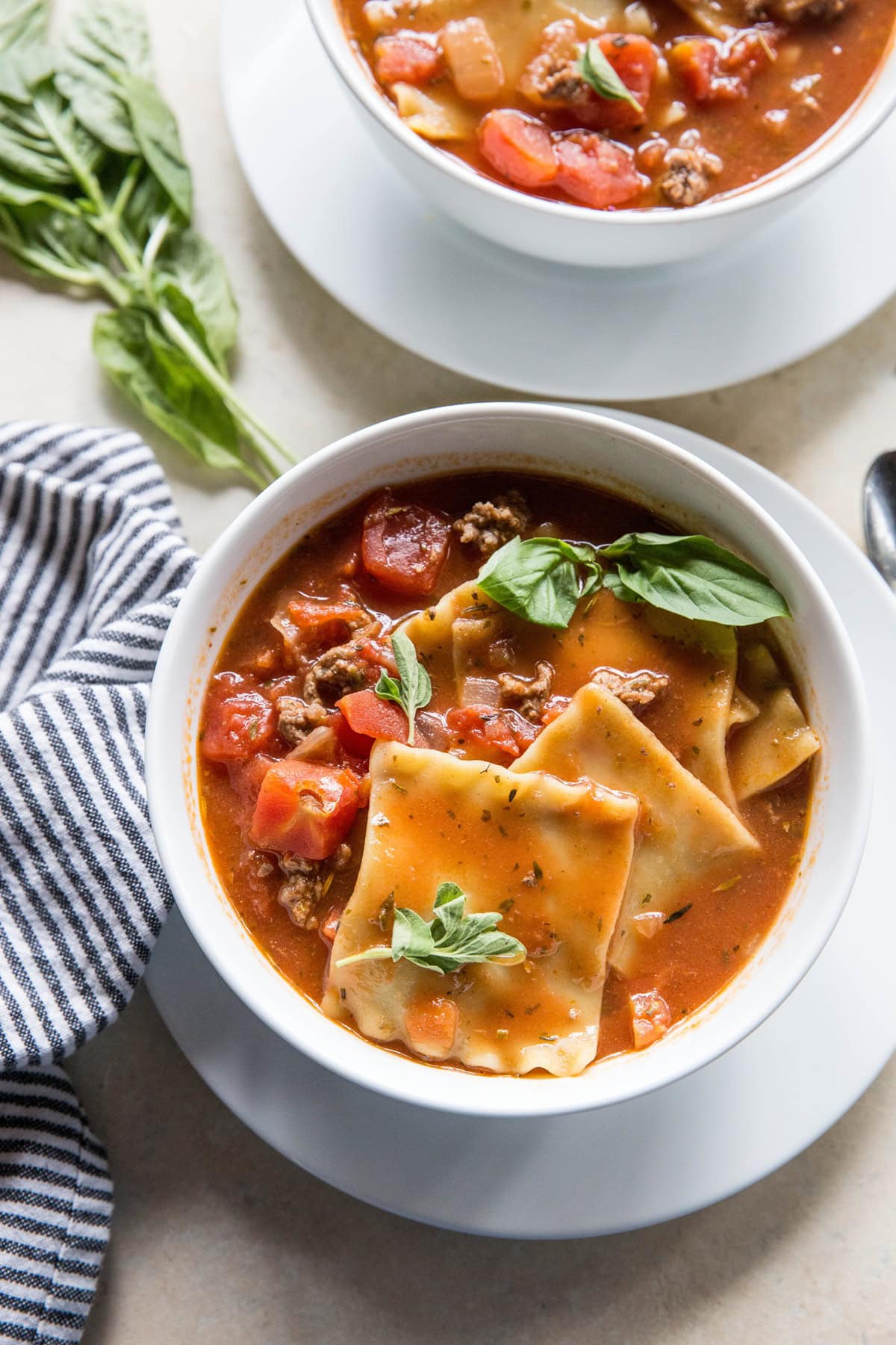 Two white bowls full of lasagna soup