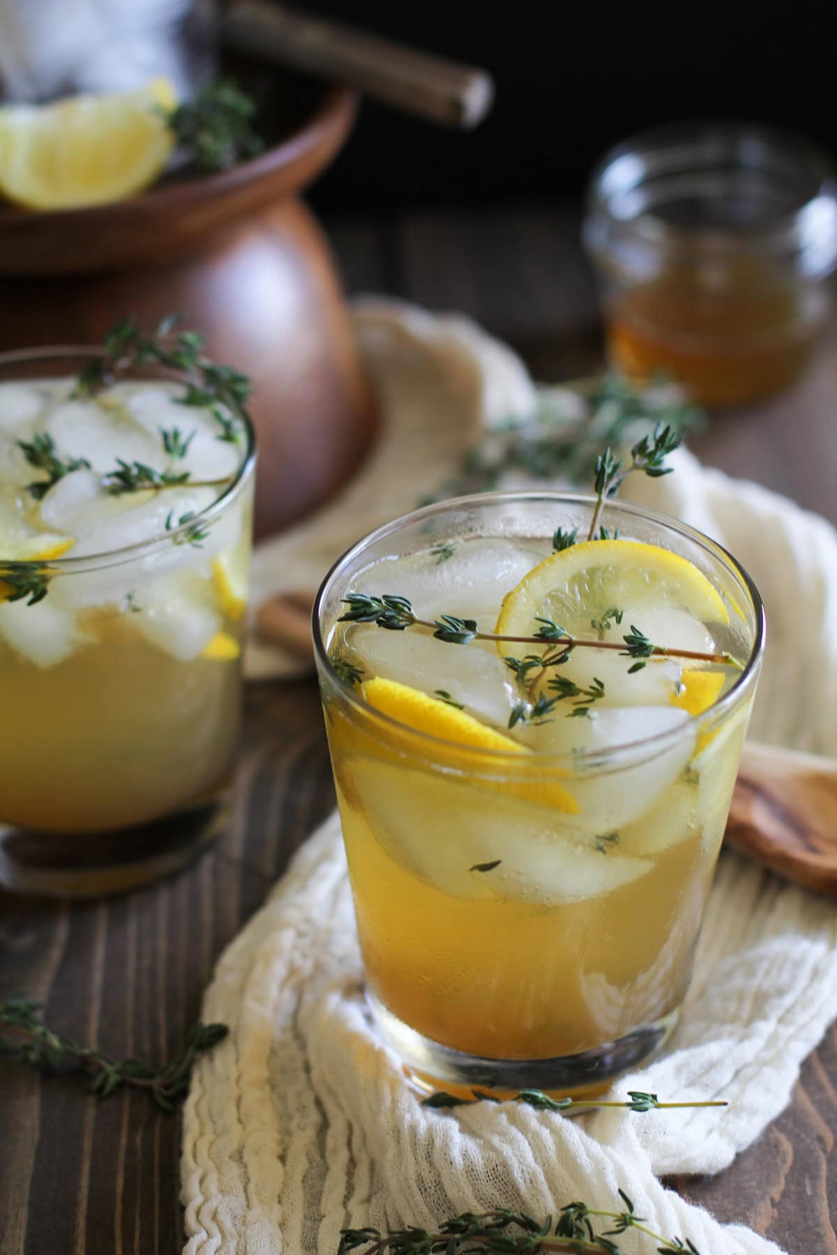 Lemon Thyme Bourbon Cocktails on a wooden background with fresh sprigs of thyme everywhere.
