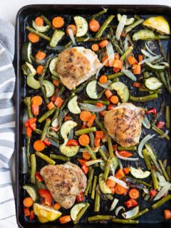 Large sheet pan of veggies and chicken thighs fresh out of the oven.