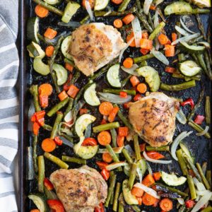 Large sheet pan of veggies and chicken thighs fresh out of the oven.
