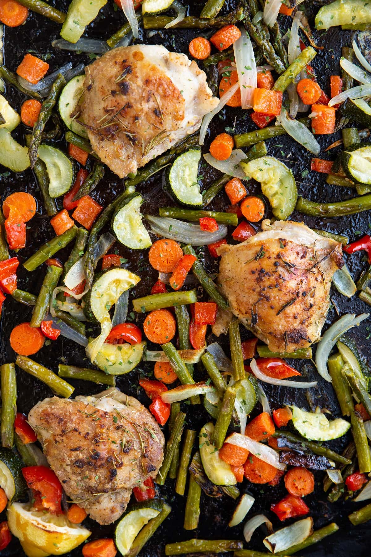 Sheet pan with crispy chicken thighs and vegetables.