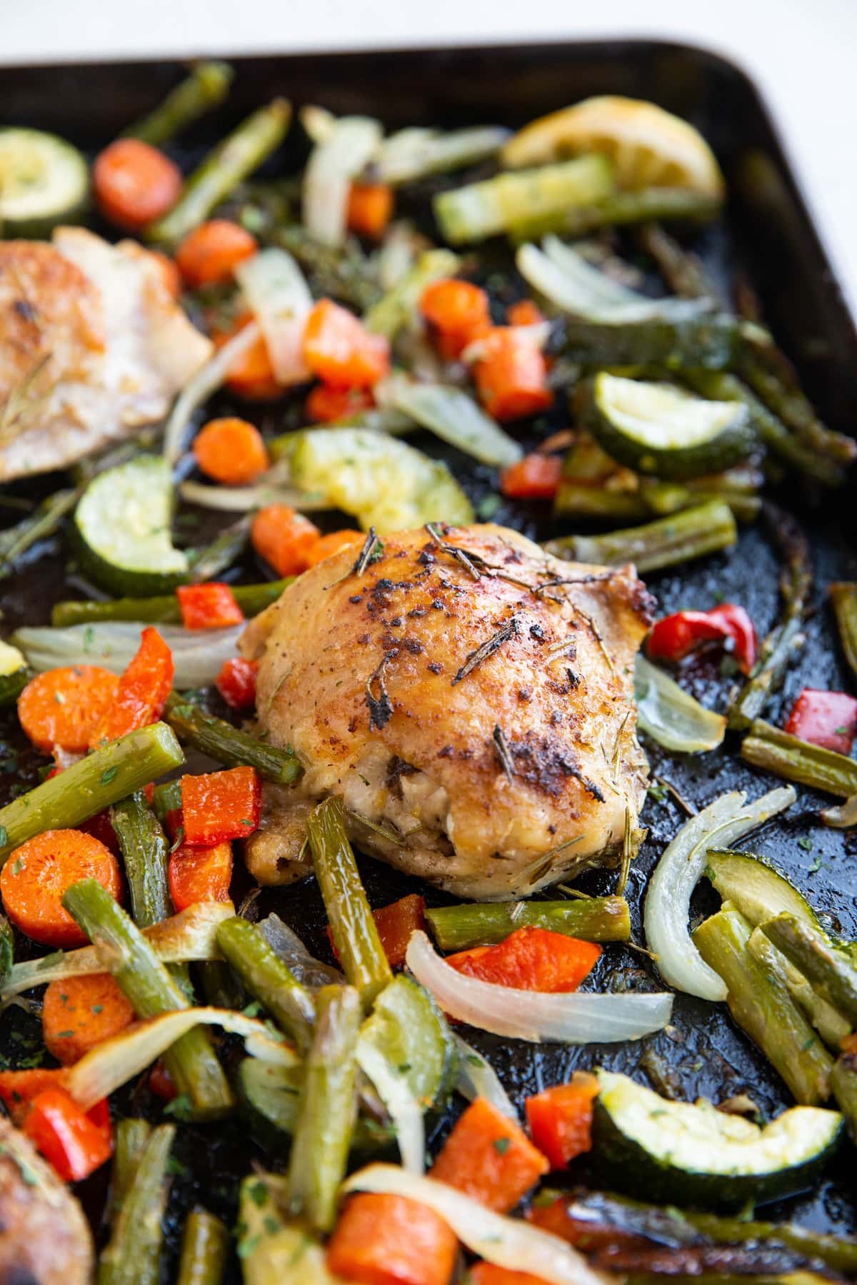 Sheet pan with roasted vegetables and chicken thighs.