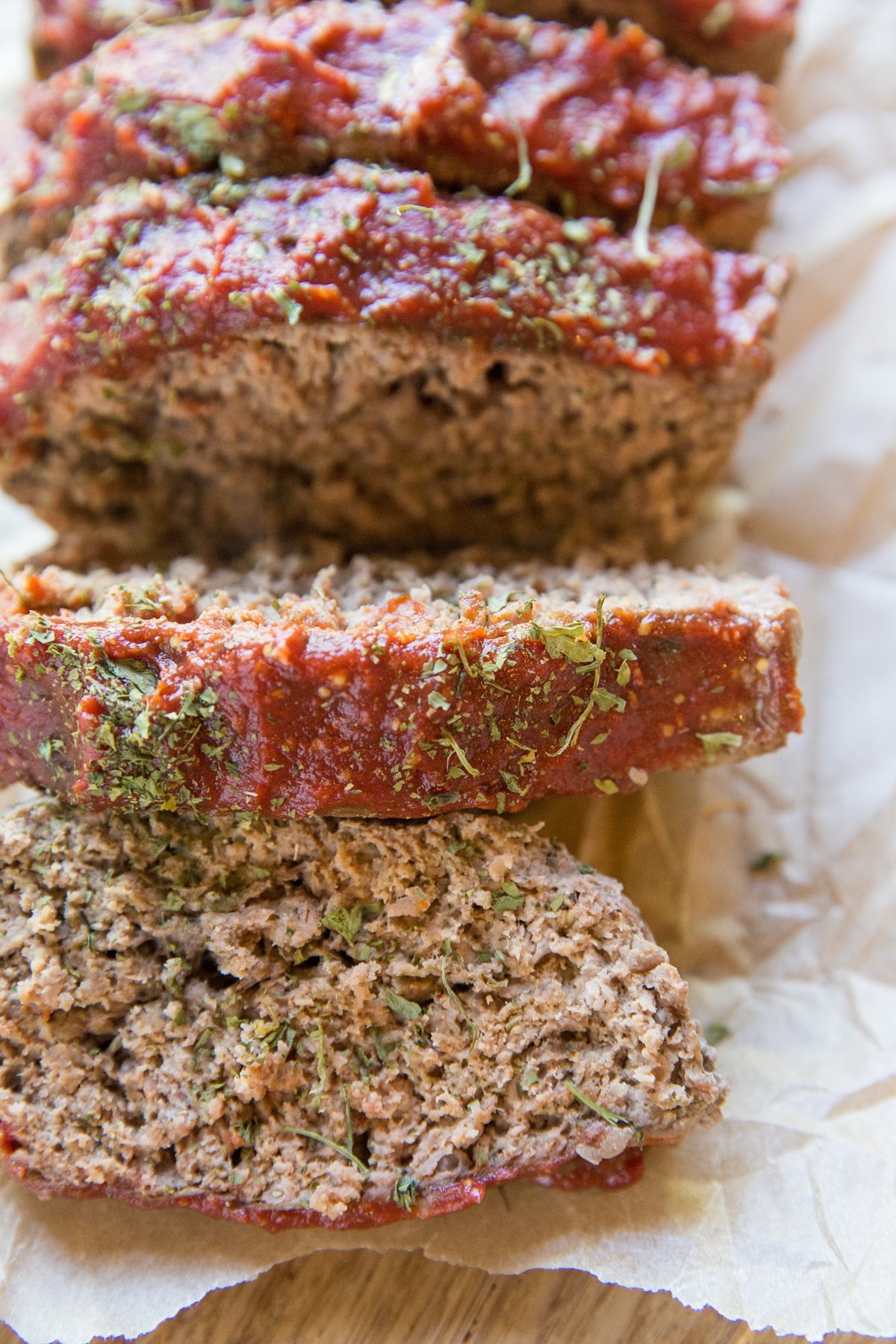 Sliced meatloaf on a sheet of parchment paper, ready to serve.