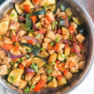 large skillet full of chopped chicken and vegetables, mixed up and fully cooked and ready to serve.
