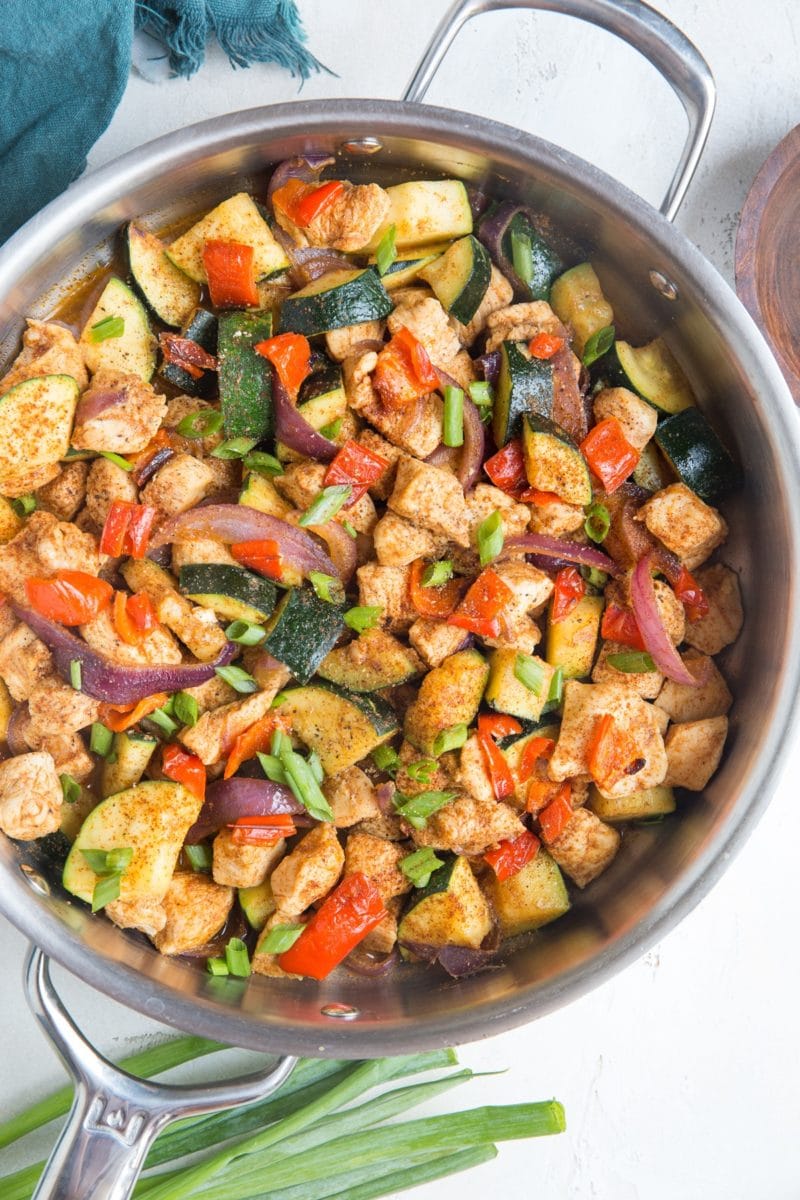 large skillet full of chopped chicken and vegetables, mixed up and fully cooked and ready to serve.