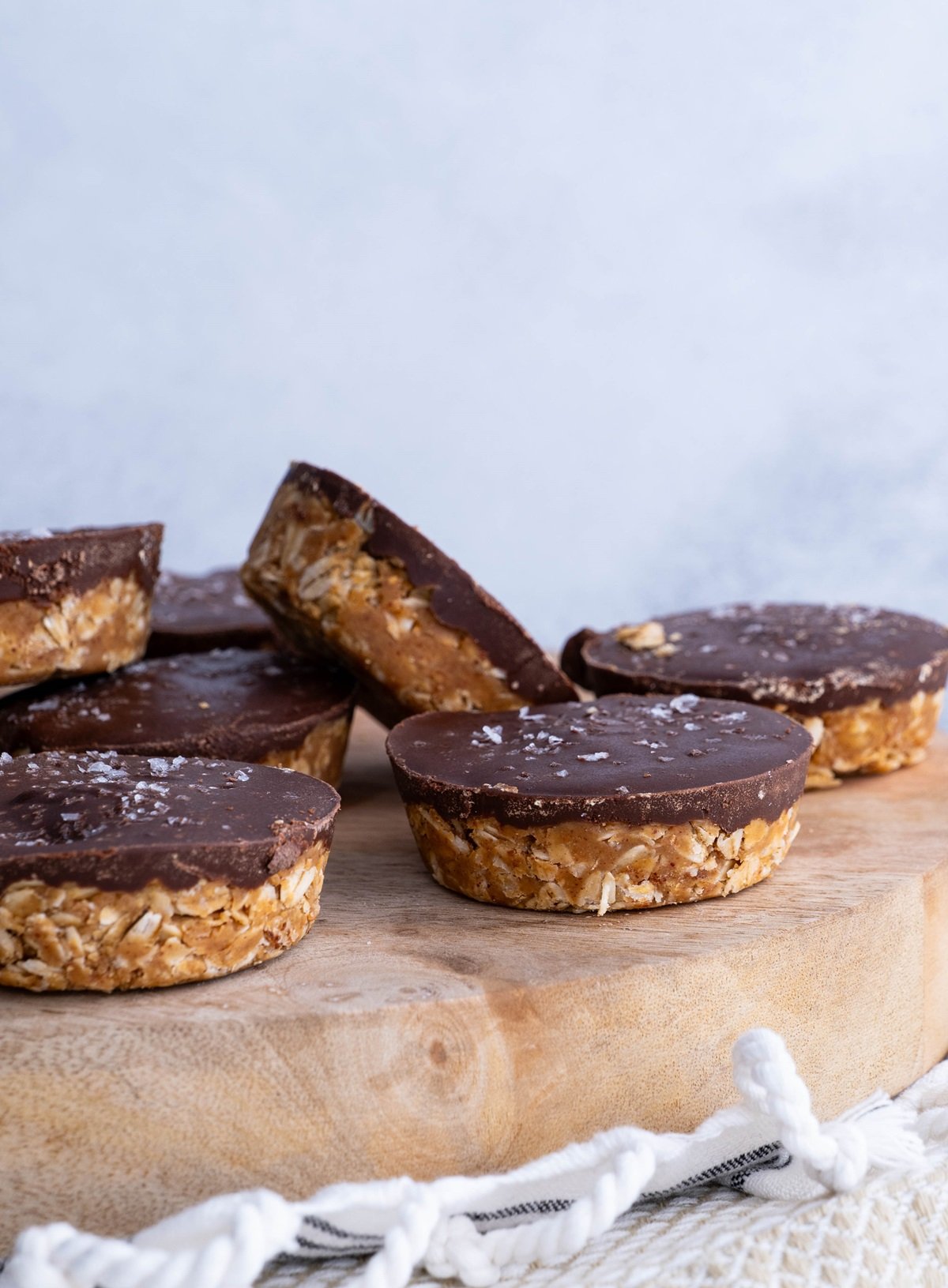 White plate of chocolate oatmeal peanut butter cups with sea salt sprinkled on top.