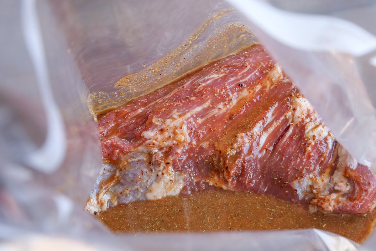 Tri tip marinating in a zip lock bag with marinade.