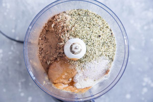 wet ingredients and dry ingredients for peanut butter protein balls in a food processor, ready to mix together.