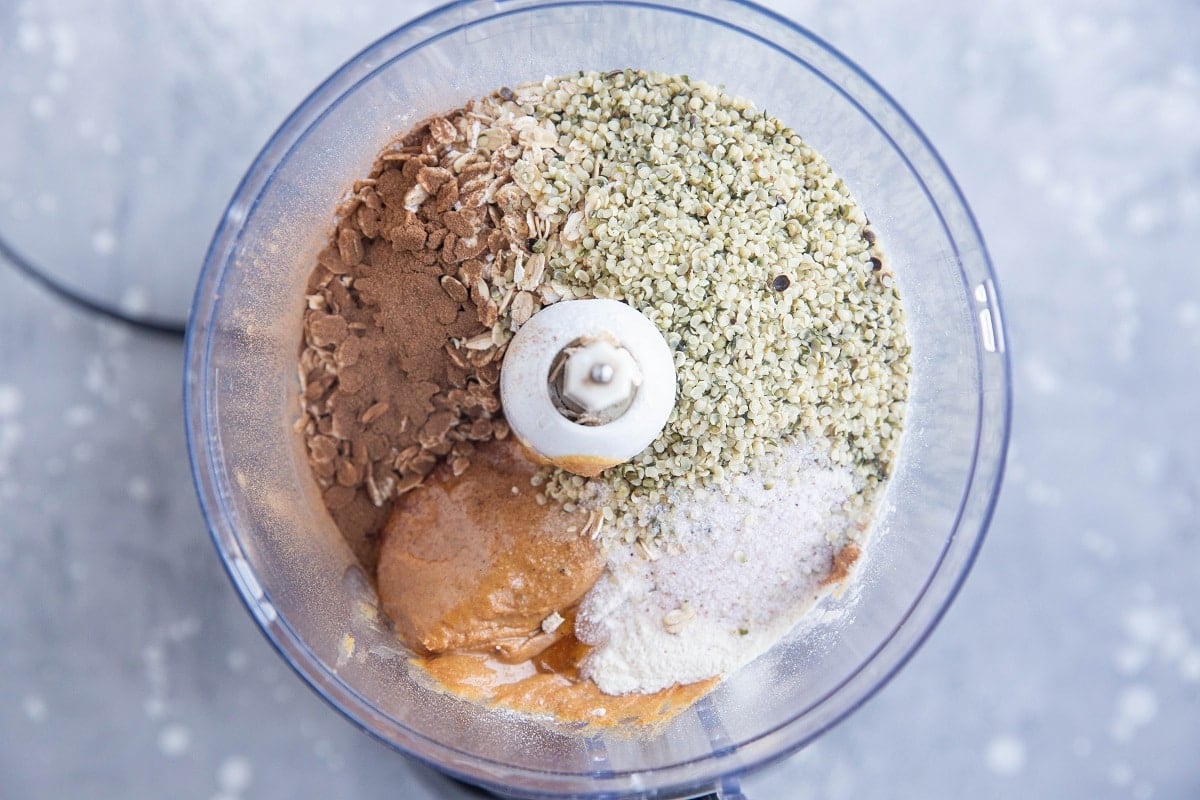 wet ingredients and dry ingredients for peanut butter protein balls in a food processor, ready to mix together.
