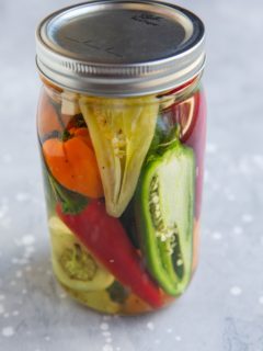 Jar of pickled peppers, ready to be preserved.