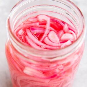 large jar of pickled red onions, ready to eat.