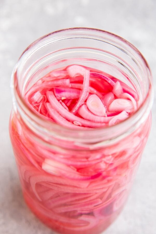 large jar of pickled red onions, ready to eat.