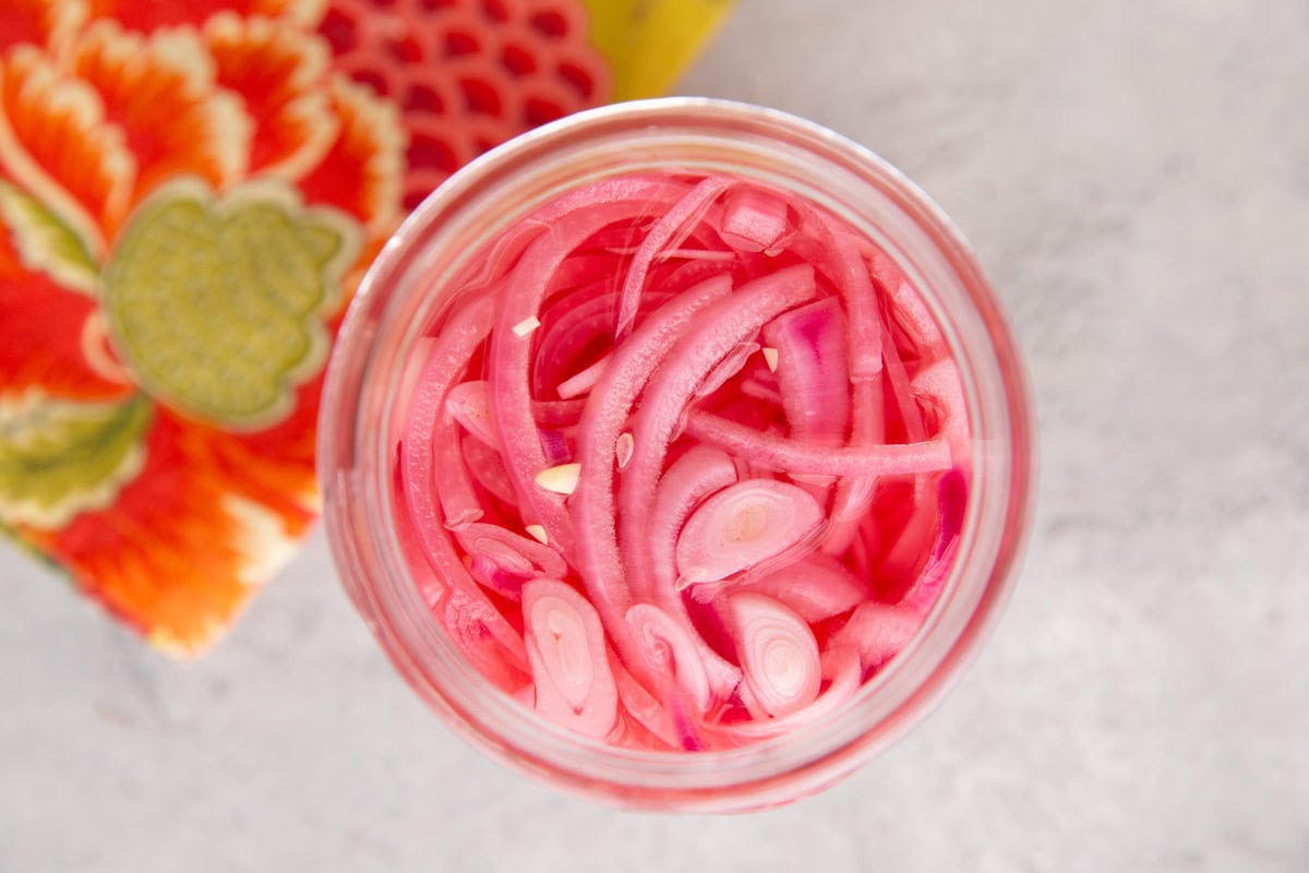 Jar of pickled onions with a napkin to the side. Ready to add to a meal.
