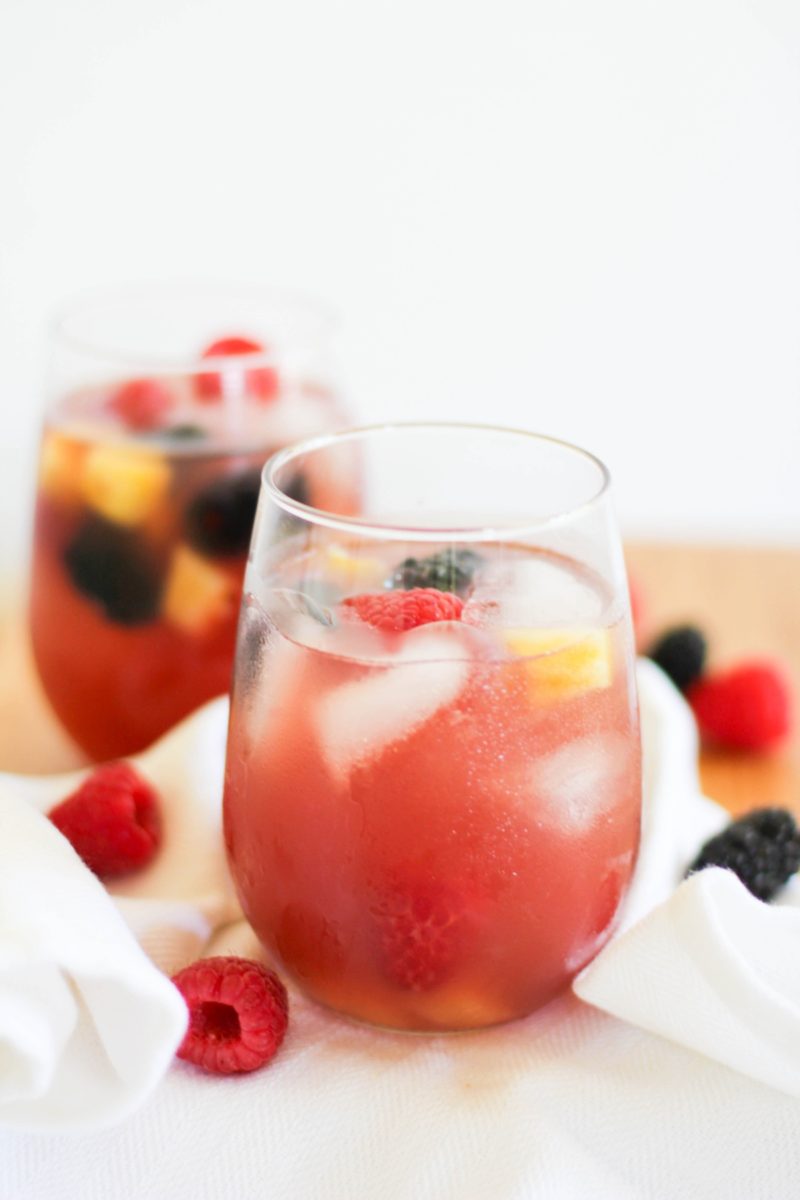 Pineapple Rosé Sangria in a glass with fresh fruit and a white napkin