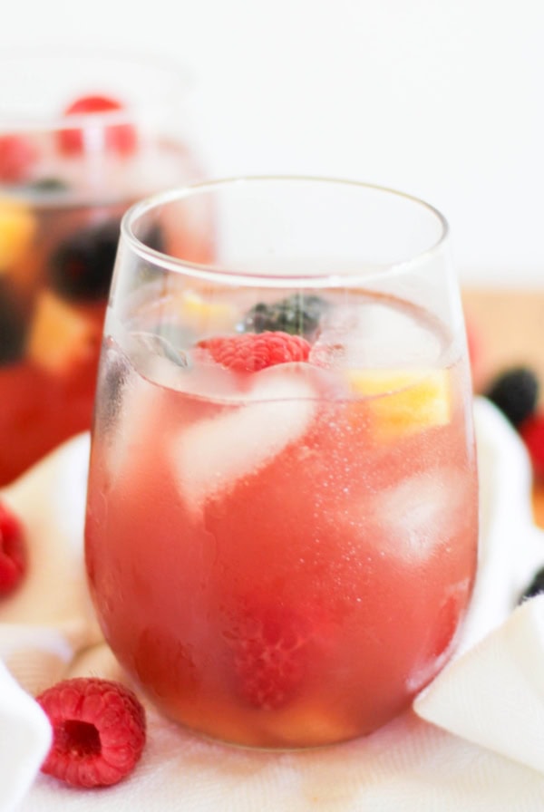 Pineapple sangria in a wine glass with fresh fruit and ice