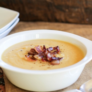 Bowl of cauliflower soup with crispy bacon on top.