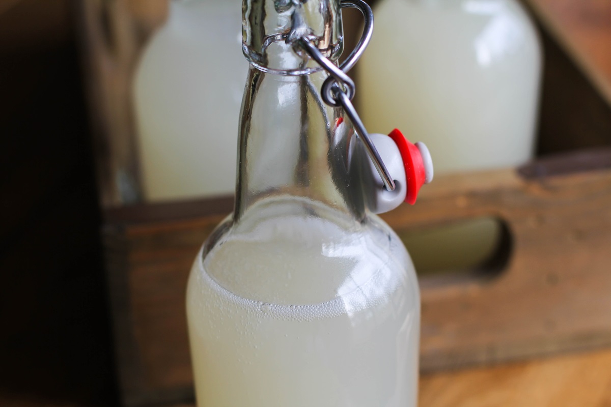 Close up on open bottle of ginger beer with two bottles of ginger beer in the background