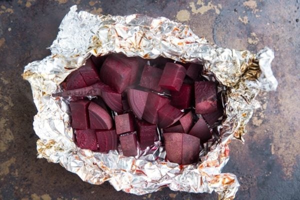 Cooked beets after roasting in a sheet of foil on a baking sheet.