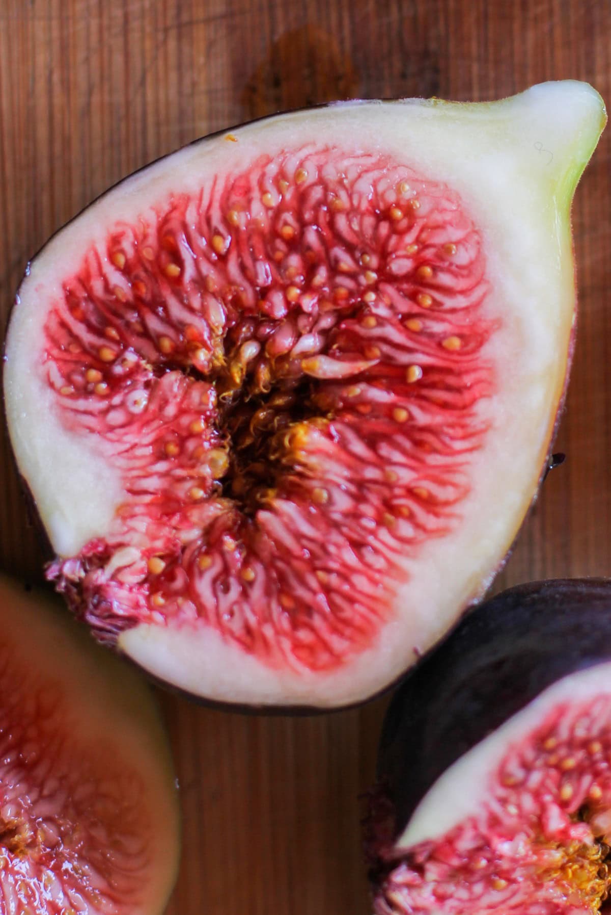 Fresh whole figs sliced in half, revealing the wild center.